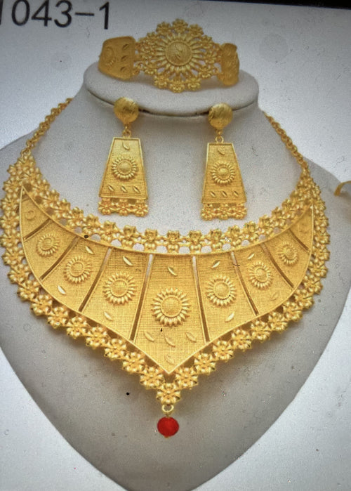 Gold necklace and earrings set on a mannequin bust with a white background